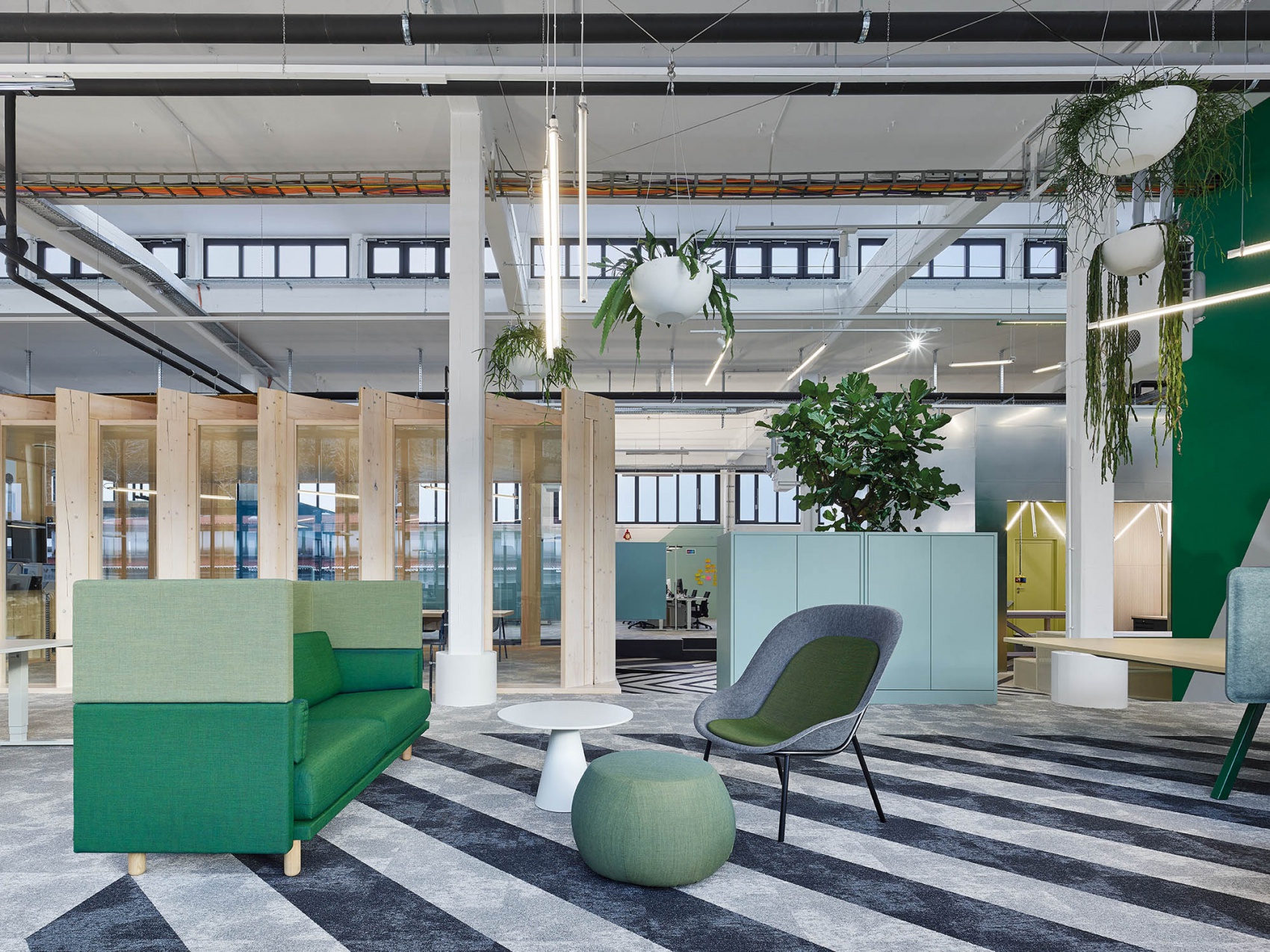 Green design of the lounge zone inside Bosch AS office with Arnhem sofa and Nook lounge chair by  De Vorm 